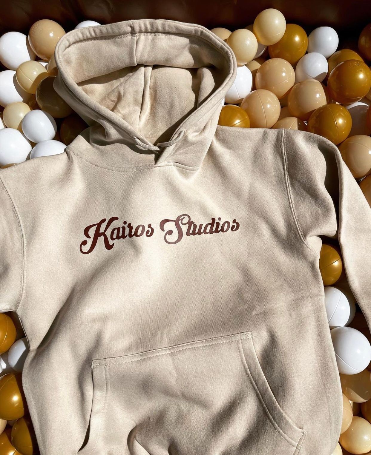 kairos studios cream hoodie on gold balls